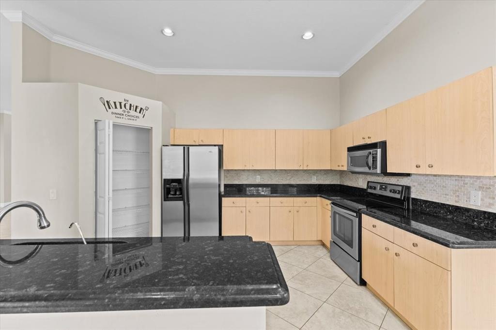 1441 Cardinal Way Weston, FL 33327 - Photo 19 of 96 a kitchen with stainless steel appliances granite countertop a stove a sink and a refrigerator