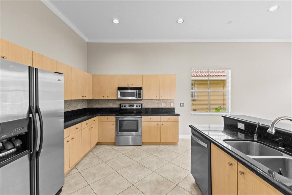 1441 Cardinal Way Weston, FL 33327 - Photo 20 of 96 a kitchen with stainless steel appliances granite countertop a sink stove oven and refrigerator
