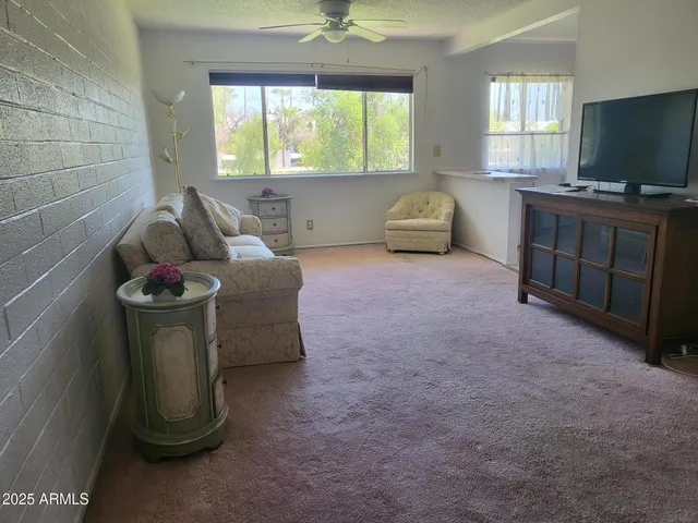 a living room with furniture a window and a flat screen tv