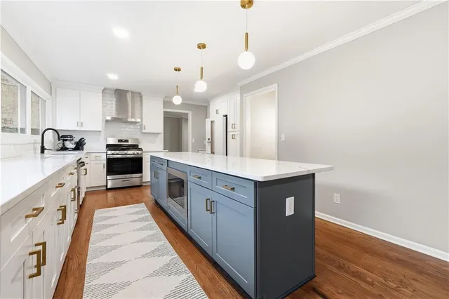 a large kitchen with stainless steel appliances a sink and cabinets