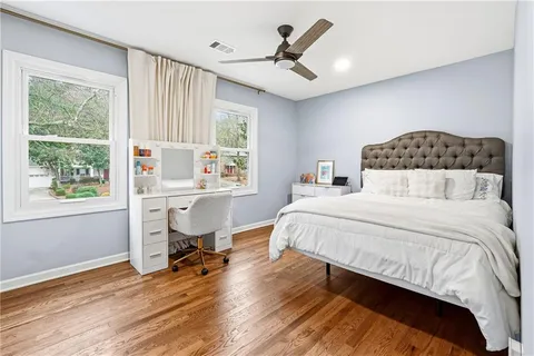 a bedroom with a bed a table and a large window