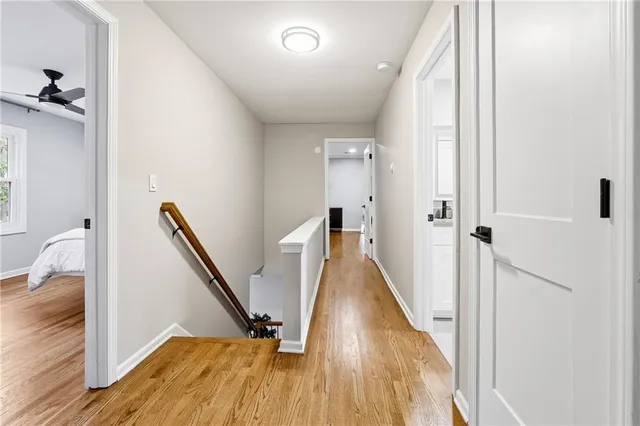 a view of a hallway with wooden floor and staircase