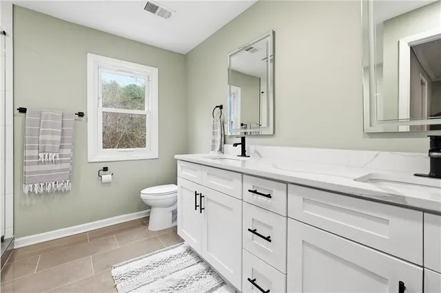 a bathroom with a toilet sink and mirror