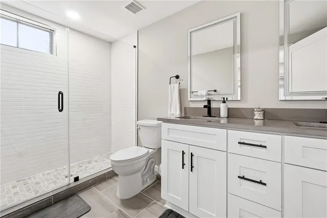 a bathroom with a double vanity sink toilet and shower