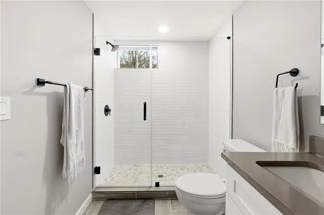 a bathroom with a granite countertop sink toilet and shower