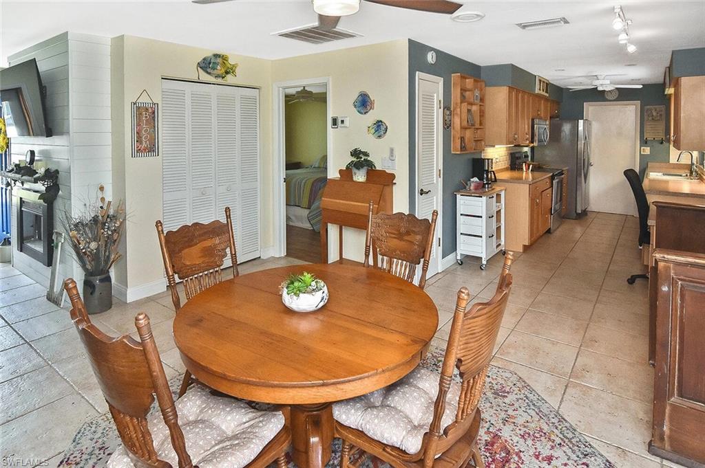 19031 Evergreen Road Fort Myers, FL 33967 - Photo 13 of 44 a dining room with furniture a rug a potted plant and wooden floor