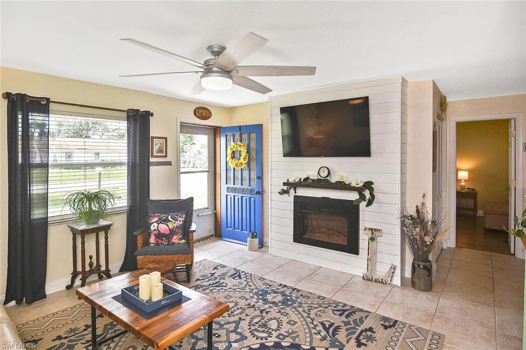 19031 Evergreen Road Fort Myers, FL 33967 - Photo 6 of 44 a living room with furniture a flat screen tv and a fireplace