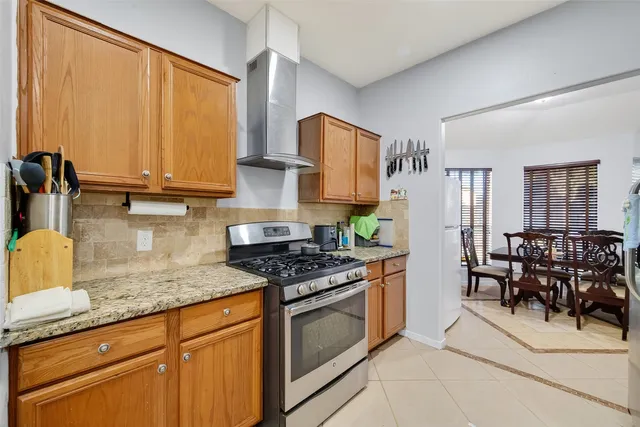 a kitchen with stainless steel appliances granite countertop a stove a sink and a microwave