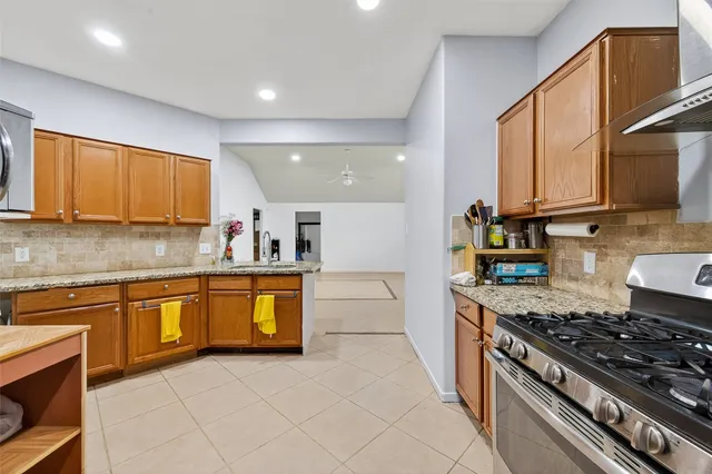 a kitchen with stainless steel appliances granite countertop a stove a sink and a microwave