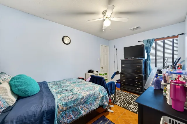a bedroom with a bed a chandelier and a flat screen television