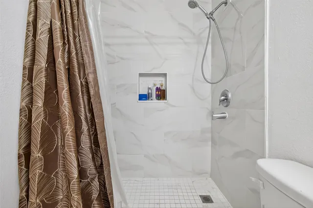 a bathroom with a shower curtain and a glass door