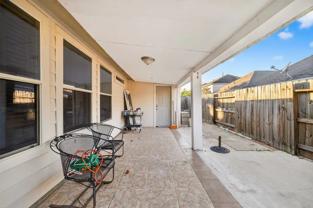 a view of the patio with table and chairs and wooden fence