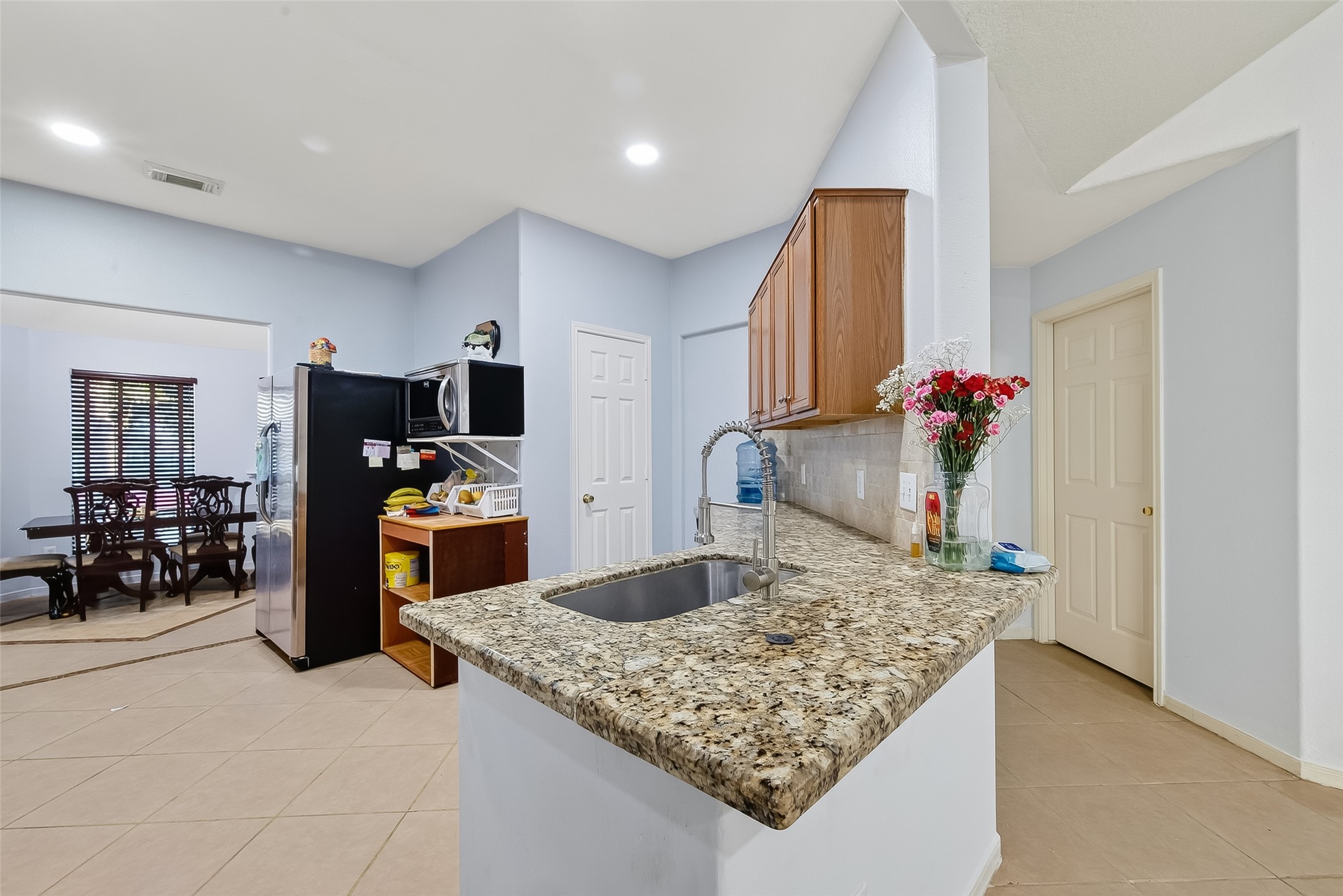 19322 Dawn Canyon Road Houston, TX 77084 - Photo 9 of 33 a kitchen with kitchen island sink refrigerator and microwave