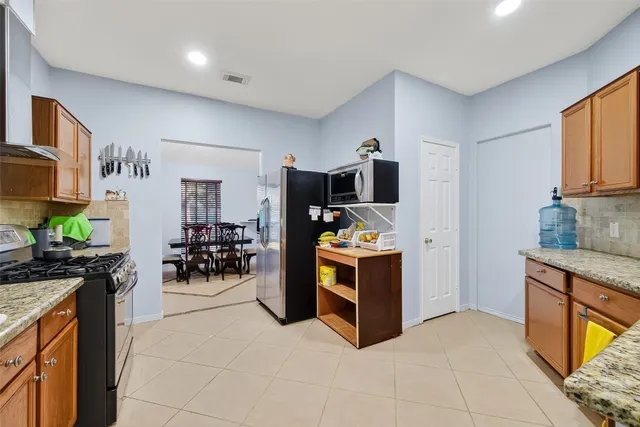 a kitchen with stainless steel appliances a stove a sink and a refrigerator
