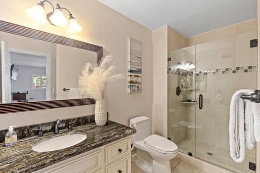 a bathroom with a granite countertop sink toilet and shower