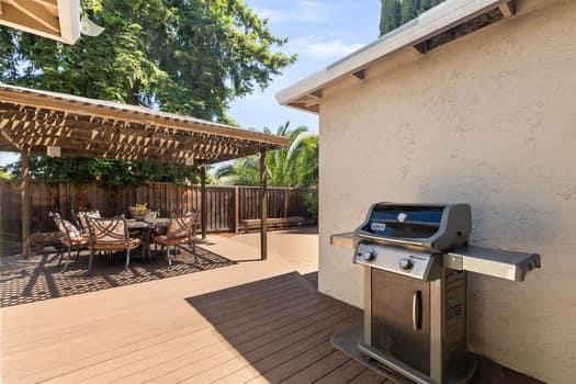a view of a patio with table and chairs with wooden floor and fence