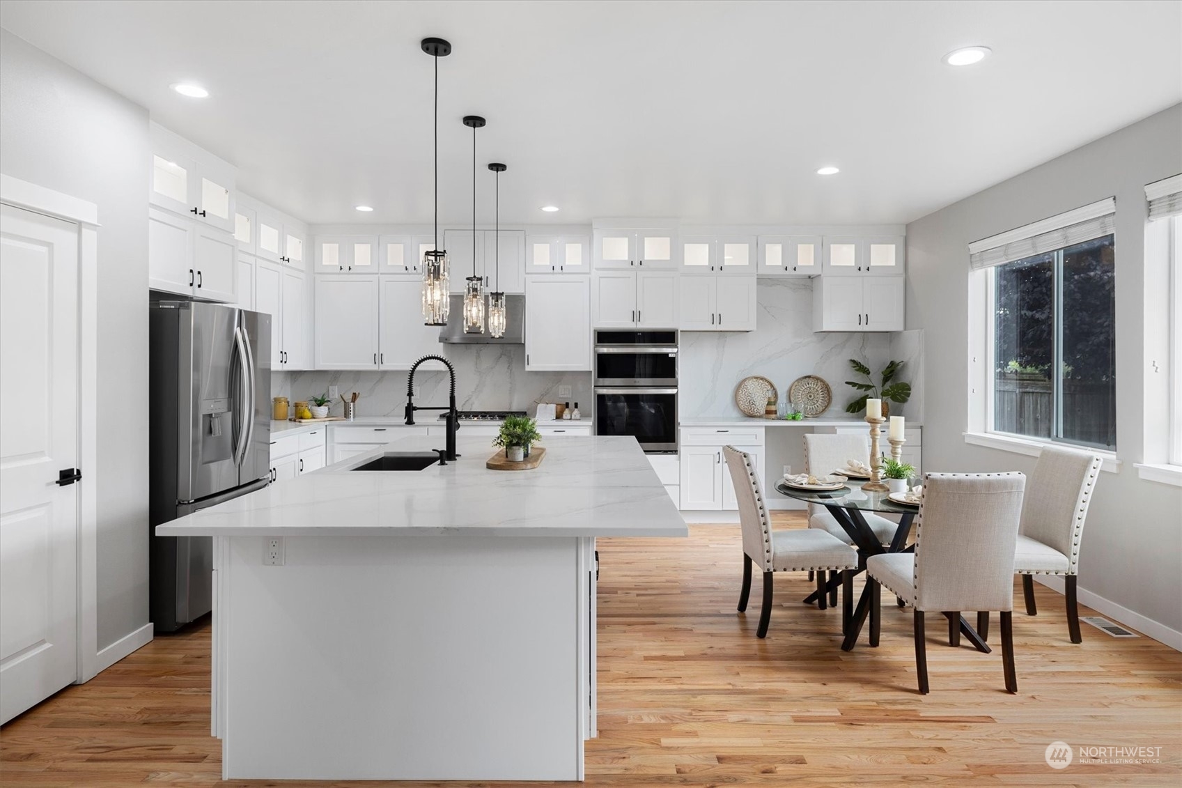 3622 222nd Place Southeast Bothell, WA 98021 - Photo 10 of 40 a kitchen with stainless steel appliances kitchen island granite countertop a dining table chairs refrigerator and sink