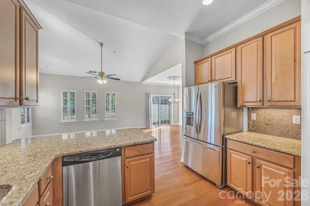 a kitchen with stainless steel appliances granite countertop a refrigerator a sink and a granite counter tops