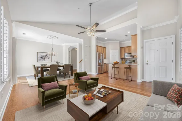 a living room with furniture a rug kitchen view and a chandelier