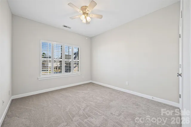 an empty room with a window and a ceiling fan