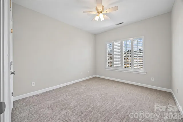 an empty room with a window and a ceiling fan