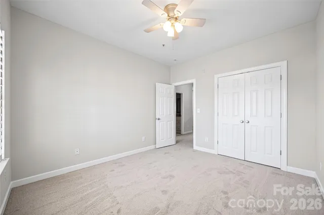 a view of an empty room and chandelier fan