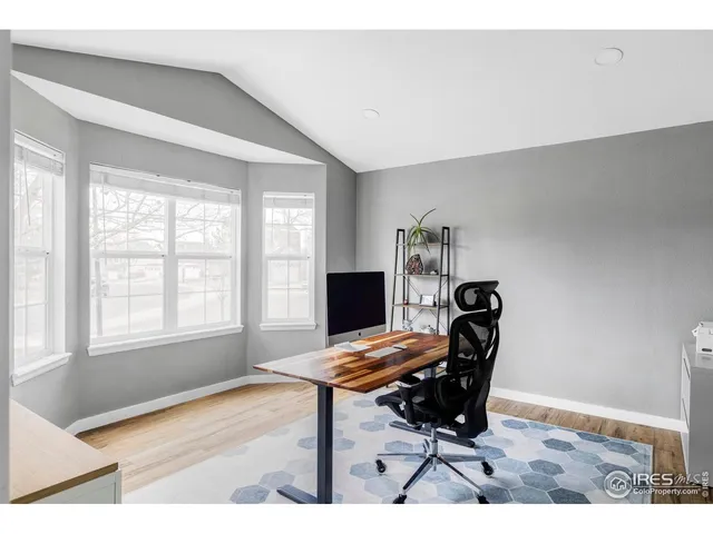 a view of a workspace with furniture and a window