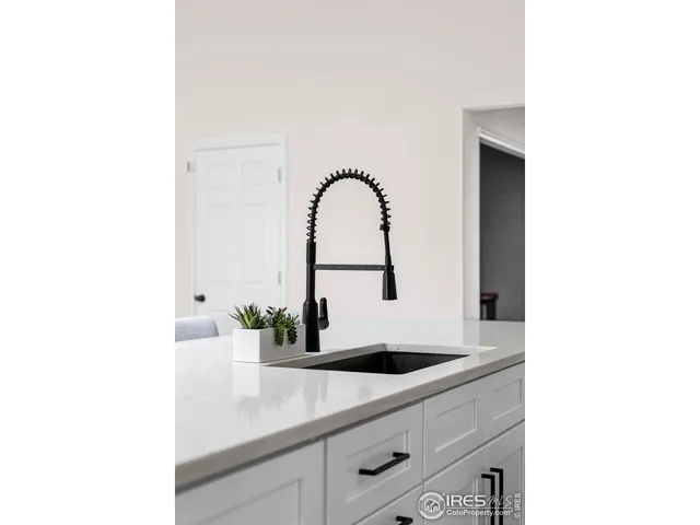 a kitchen with a sink and a stove top oven with wooden floor