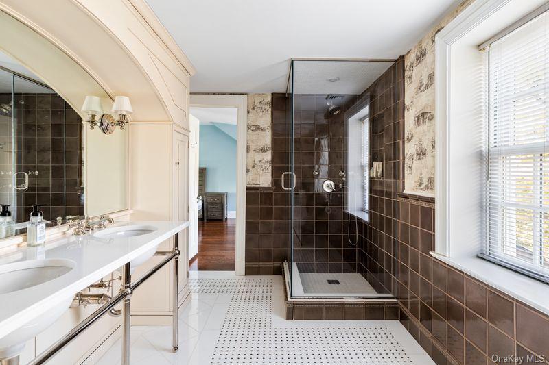 393 Mill River Road Muttontown, NY 11771 - Photo 22 of 41 a bathroom with a sink a toilet a glass door shower and a mirror