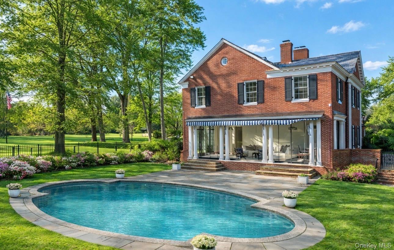 393 Mill River Road Muttontown, NY 11771 - Photo 29 of 41 a front view of a house with a yard table and chairs