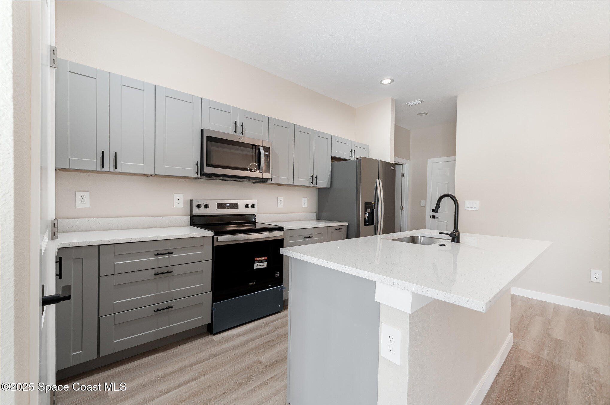 15615 Southwest 49th Avenue Road Ocala, FL 34473 - Photo 3 of 23 a kitchen with granite countertop a sink and a stove top oven with wooden floor
