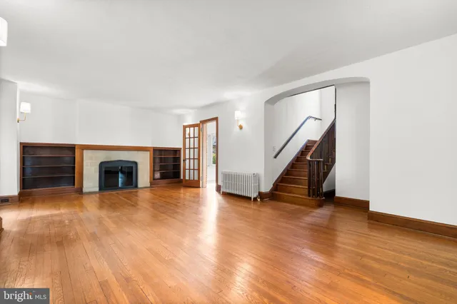 a view of an empty room with window and wooden floor