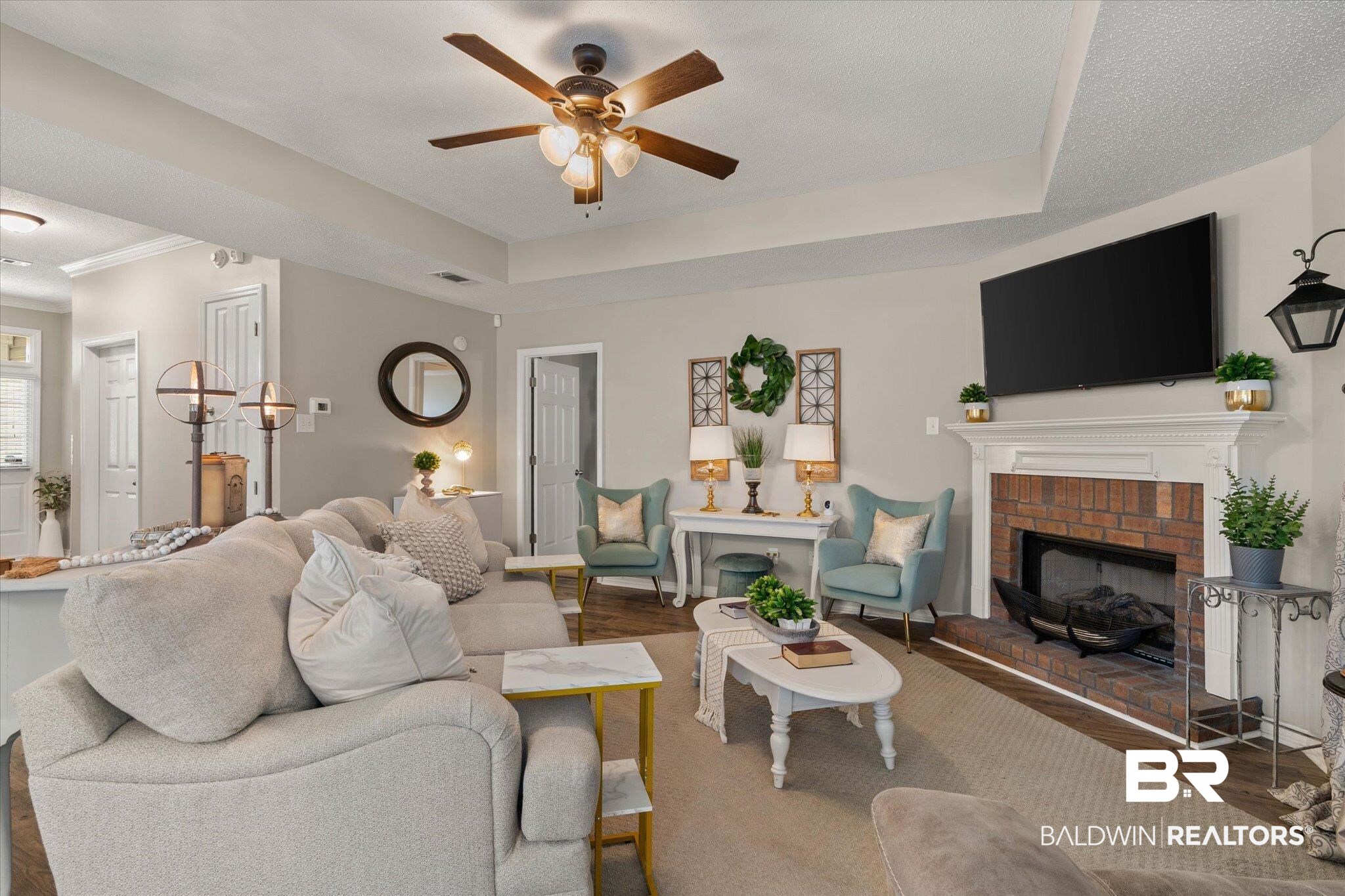 8600 Sable Court Semmes, AL 36575 - Photo 3 of 20 Living room with a ceiling fan, wood finished floors, a fireplace, and a raised ceiling