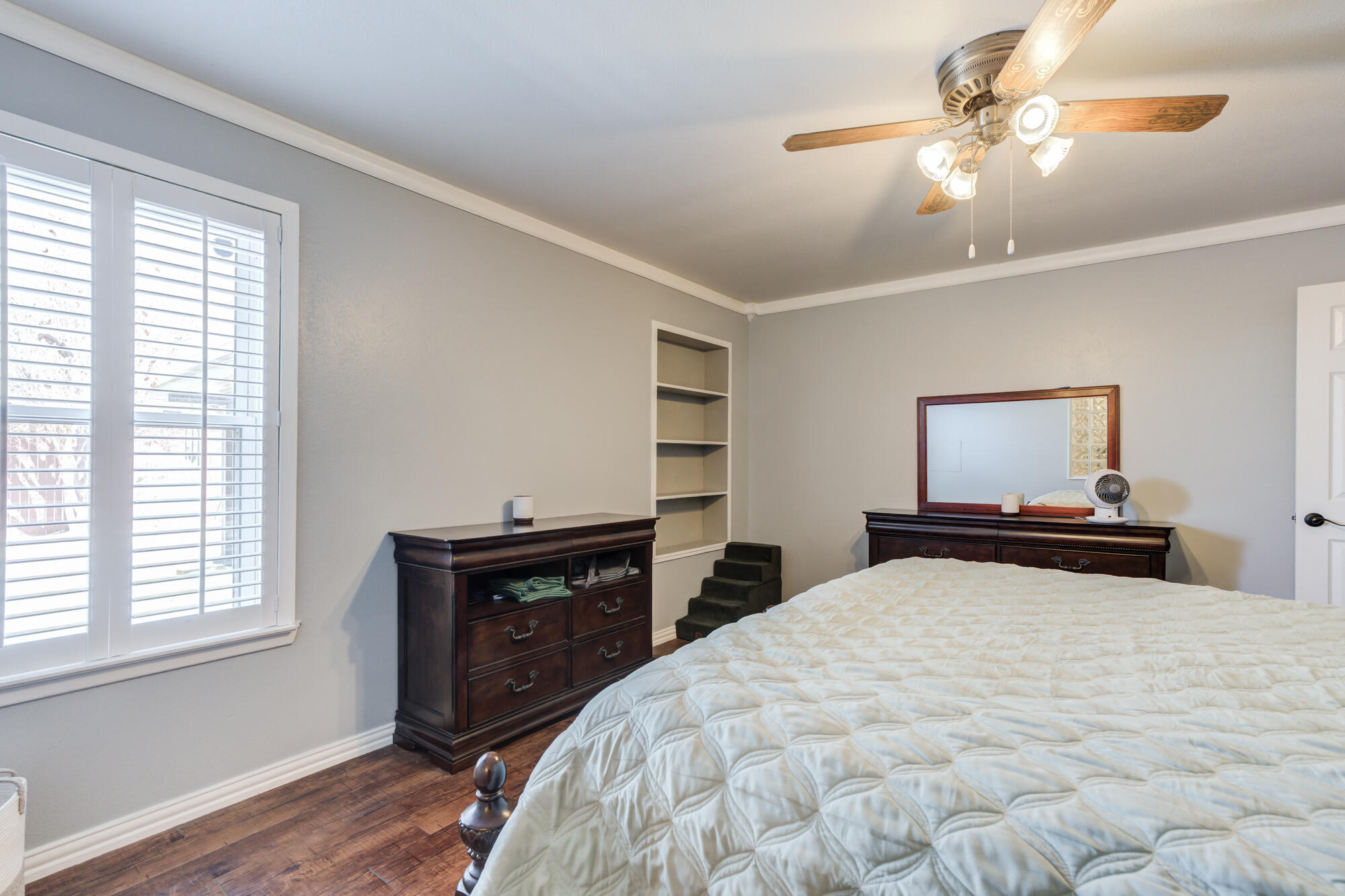 2608 74th Place Lubbock, TX 79423 - Photo 20 of 38 a bedroom with a bed and a dresser with wooden floor