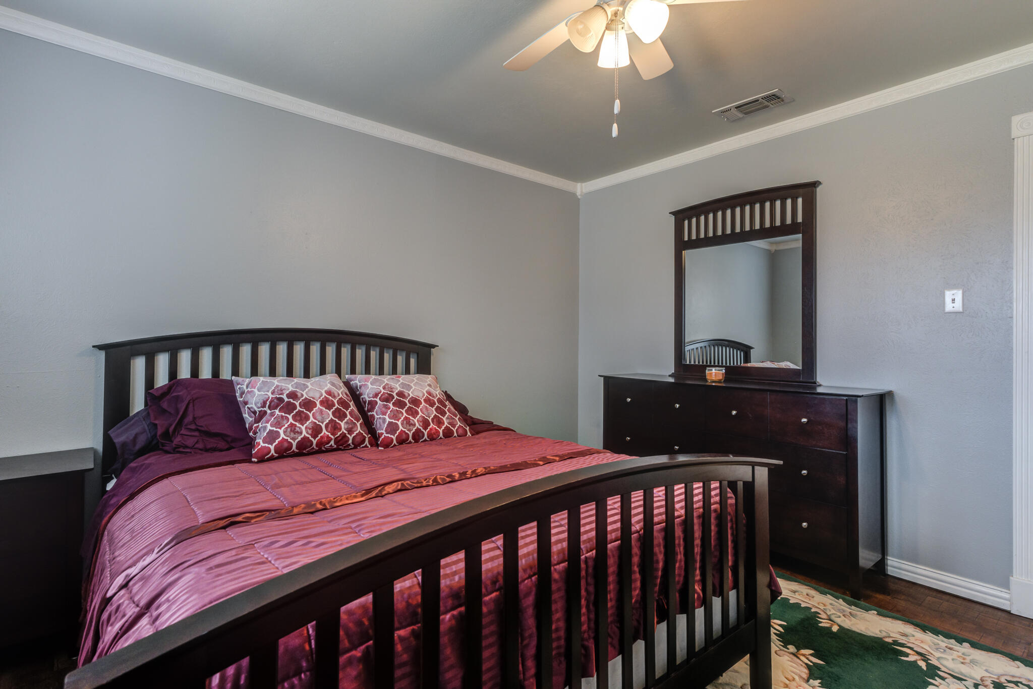 2608 74th Place Lubbock, TX 79423 - Photo 24 of 38 a bedroom with a large bed and a chandelier