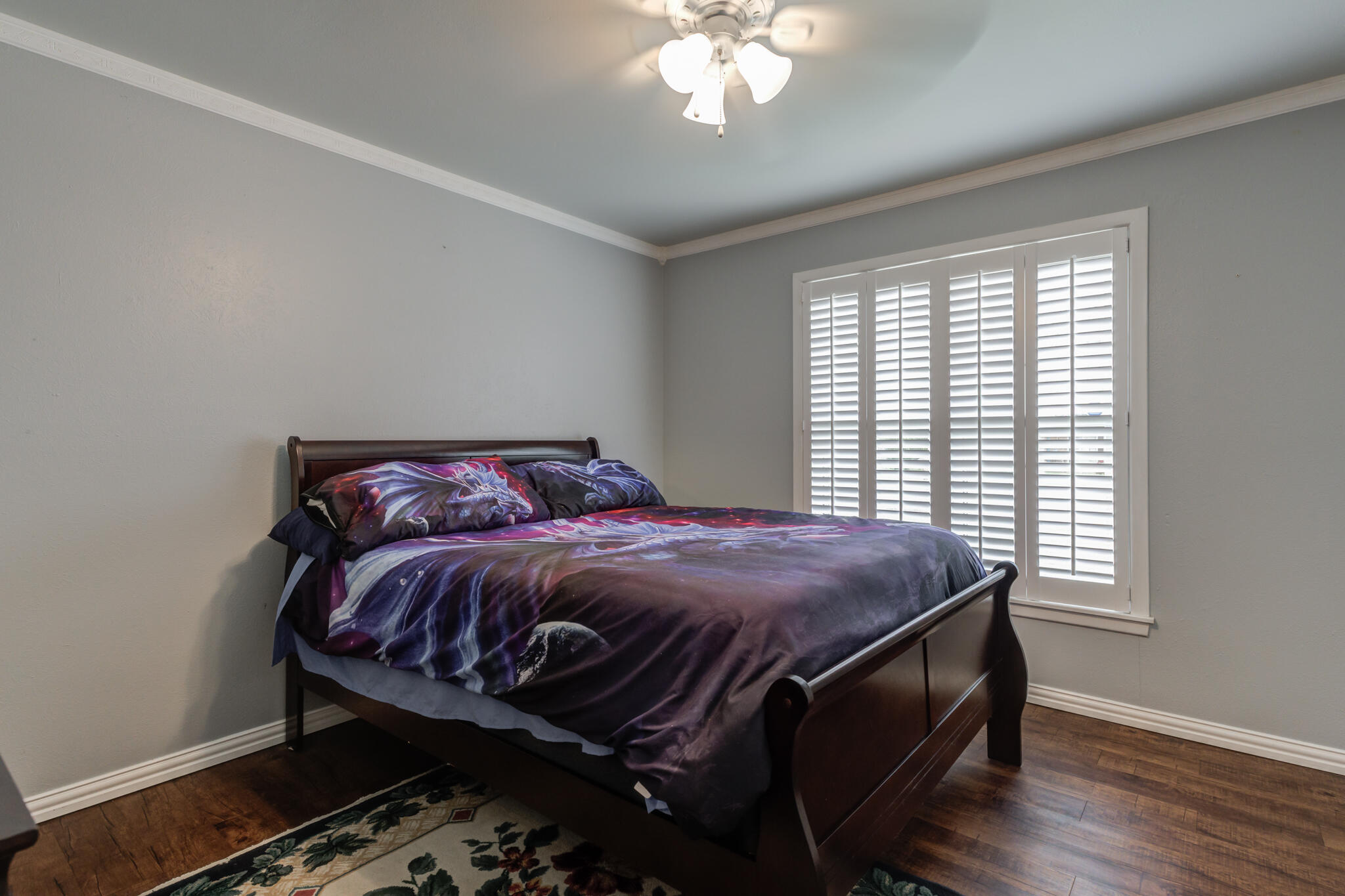 2608 74th Place Lubbock, TX 79423 - Photo 27 of 38 a bedroom with a bed and a chandelier