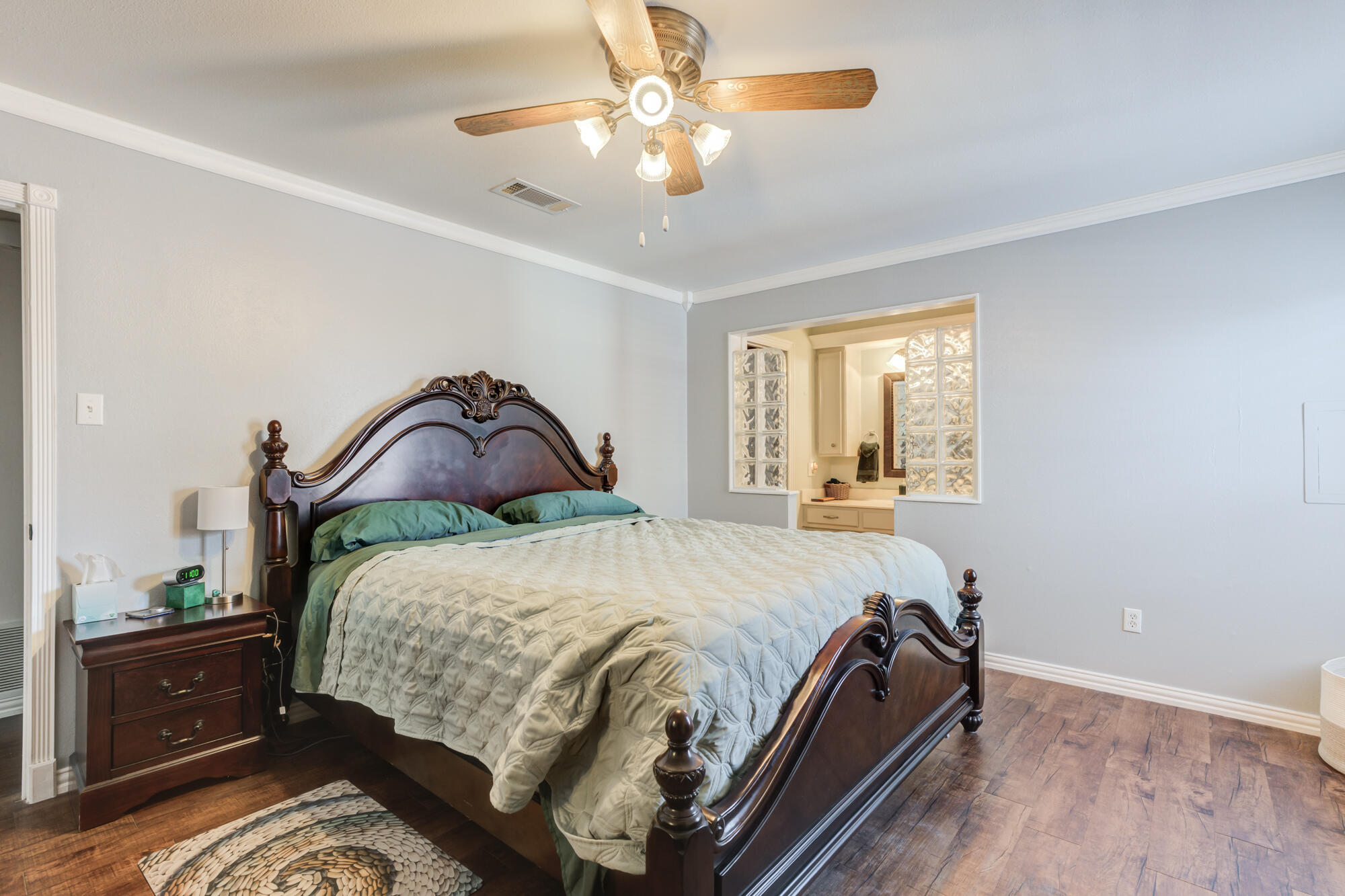 2608 74th Place Lubbock, TX 79423 - Photo 4 of 38 a bedroom with a bed and a chandelier