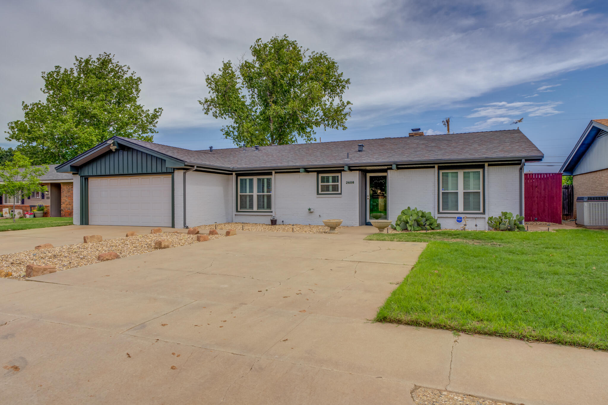 2608 74th Place Lubbock, TX 79423 - Photo 7 of 38 a front view of a house with a garden and yard