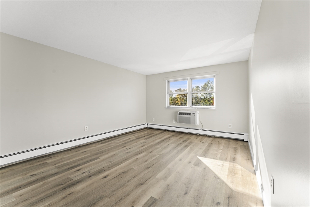1 Colonial Drive, Unit C16 Andover, MA 01810 - Photo 11 of 32 an empty room with wooden floor and window