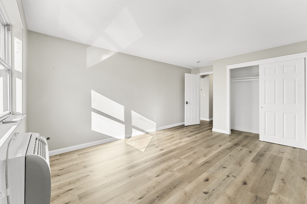 1 Colonial Drive, Unit C16 Andover, MA 01810 - Photo 14 of 32 a view of empty room with wooden floor and fan