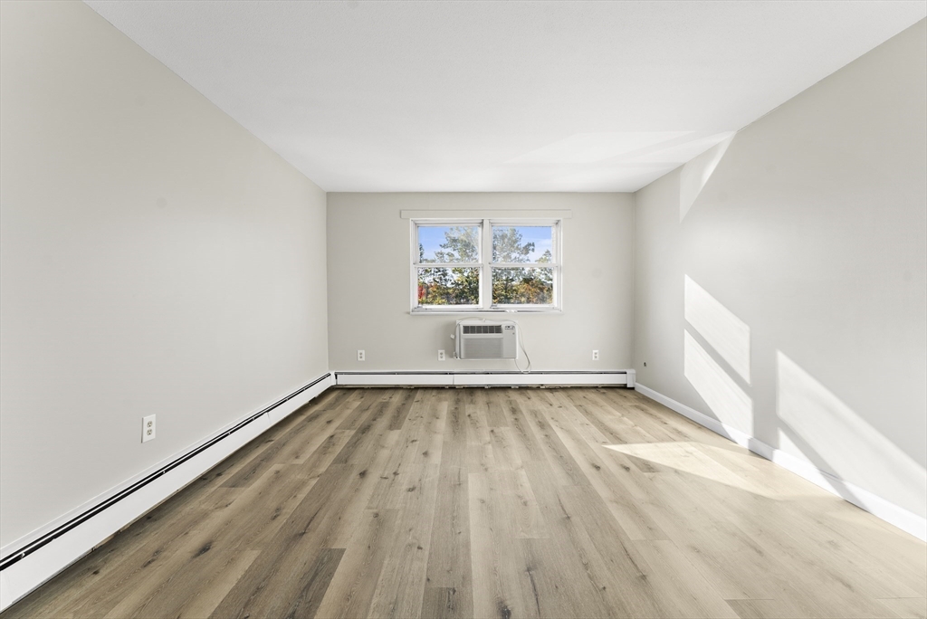1 Colonial Drive, Unit C16 Andover, MA 01810 - Photo 15 of 32 an empty room with wooden floor and windows