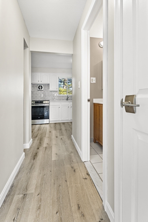 1 Colonial Drive, Unit C16 Andover, MA 01810 - Photo 18 of 32 a view of kitchen with hallway and wooden floor
