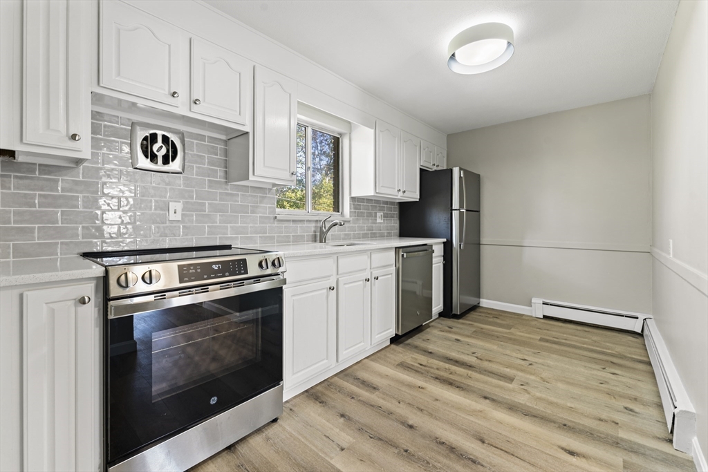 1 Colonial Drive, Unit C16 Andover, MA 01810 - Photo 23 of 32 a kitchen with a stove oven and a refrigerator