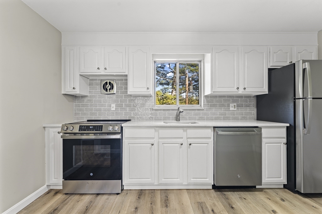 1 Colonial Drive, Unit C16 Andover, MA 01810 - Photo 24 of 32 a kitchen with stainless steel appliances granite countertop a stove a sink and a refrigerator
