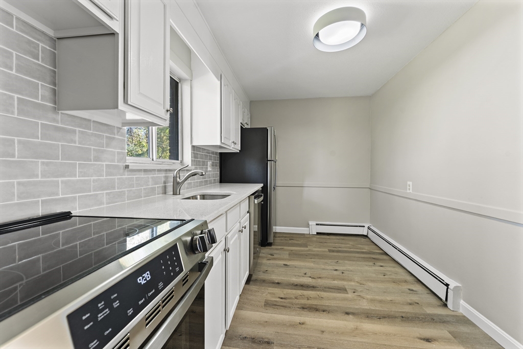 1 Colonial Drive, Unit C16 Andover, MA 01810 - Photo 25 of 32 a kitchen with a sink stove and cabinets
