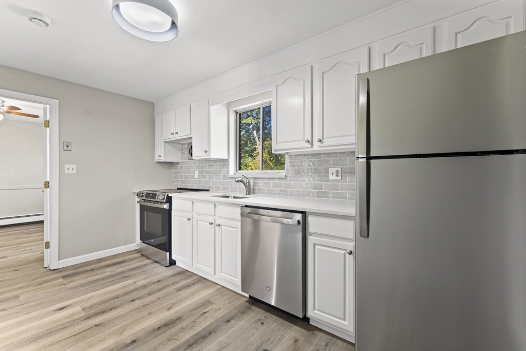 1 Colonial Drive, Unit C16 Andover, MA 01810 - Photo 26 of 32 a kitchen with a refrigerator sink stove and cabinets