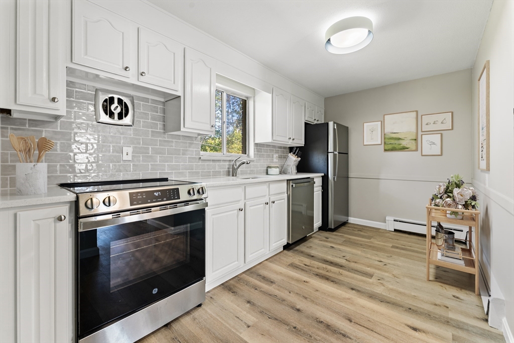 1 Colonial Drive, Unit C16 Andover, MA 01810 - Photo 4 of 32 a kitchen with stainless steel appliances granite countertop a stove and a refrigerator