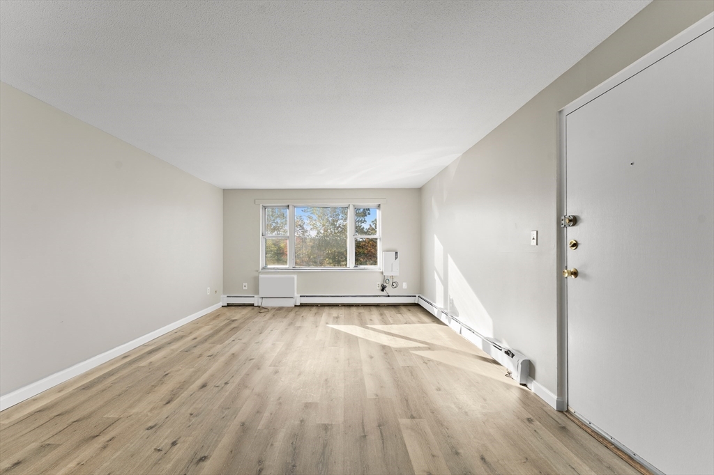 1 Colonial Drive, Unit C16 Andover, MA 01810 - Photo 8 of 32 wooden floor in an empty room with a window