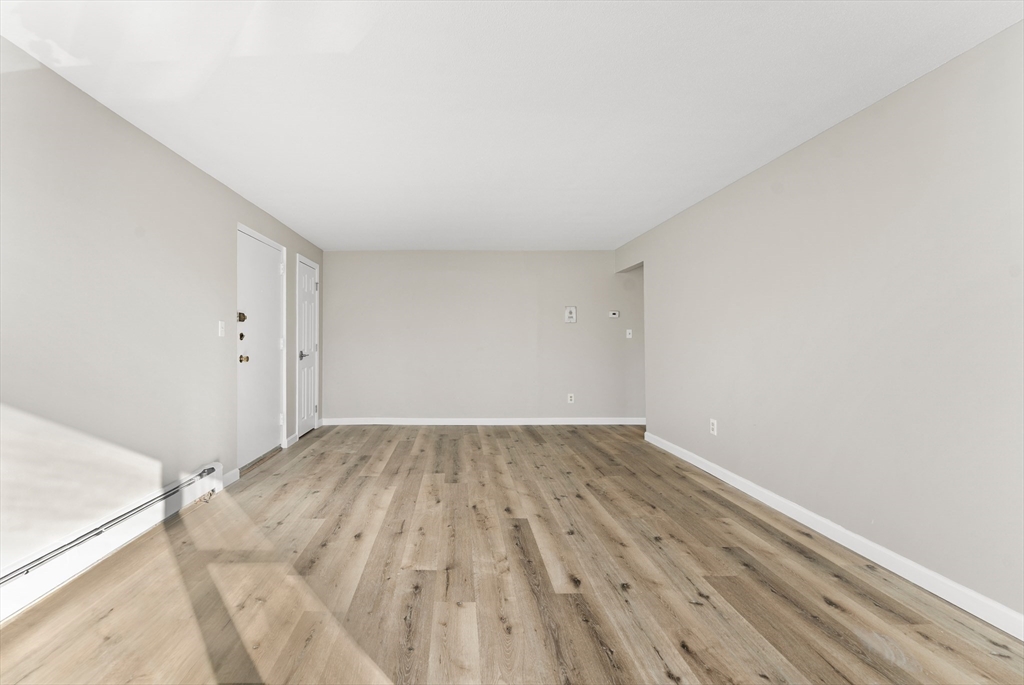 1 Colonial Drive, Unit C16 Andover, MA 01810 - Photo 9 of 32 a view of an empty room and wooden floor
