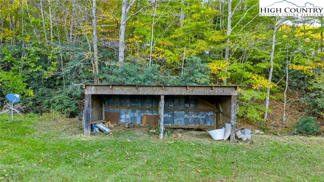 a view of an empty room with glass door and wooden floor